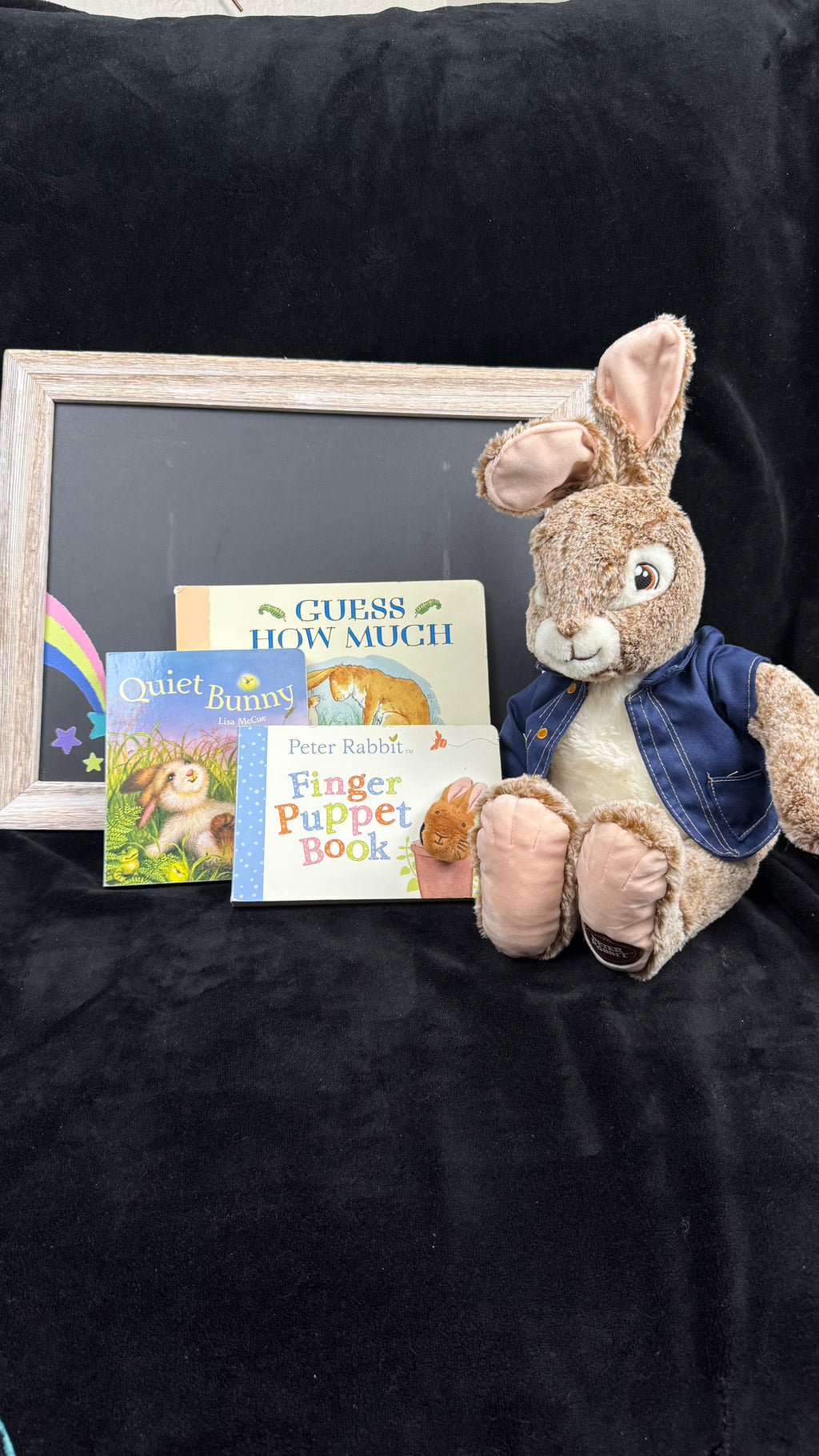 The Bunny Bundle: Guess How Much I Love You, Quiet Bunny and Peter Rabbit Finger Puppet Book beside a large Peter Rabbit plush in a blue jacket