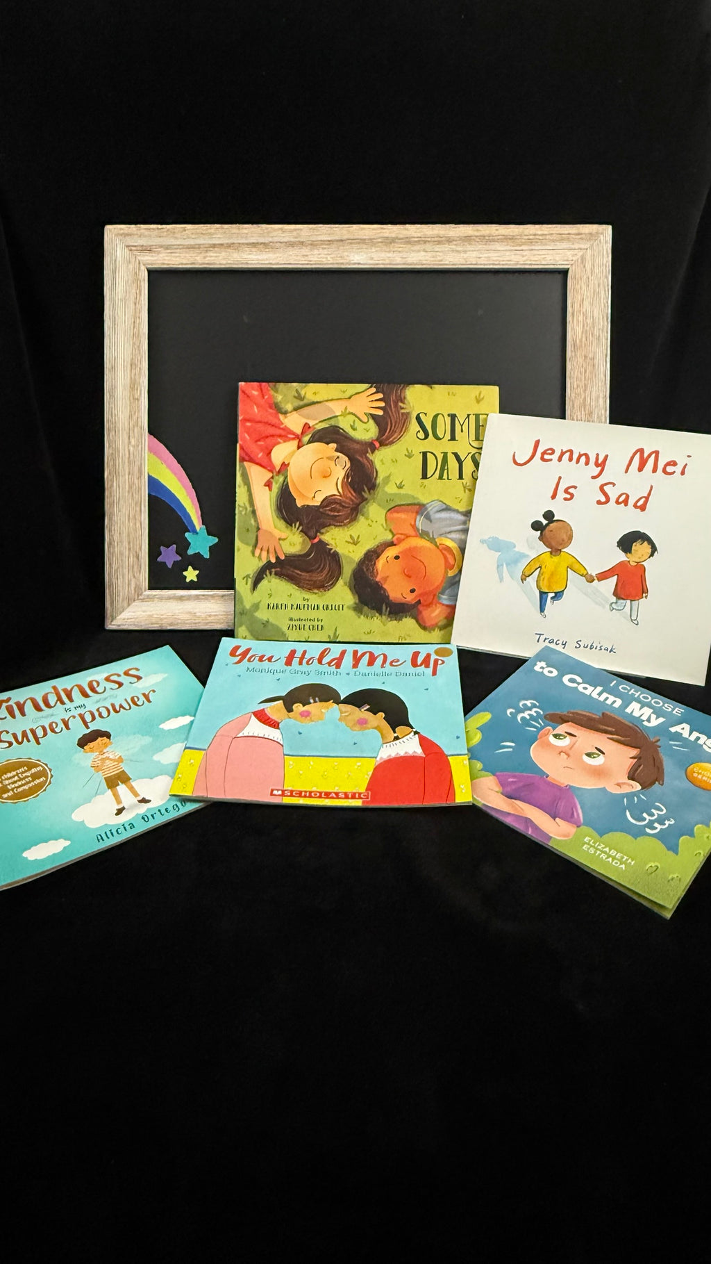 Social Emotional book bundle flat lay with chalkboard rainbow prop, five picture books about feelings